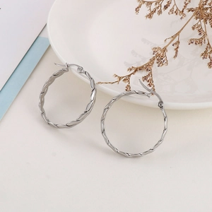 Detailed view of silver twisted hoop earrings with a polished spiral texture