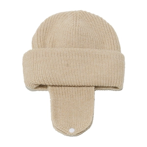 Detail of beige knit trapper hat showing thick texture and secure chin buckle closure