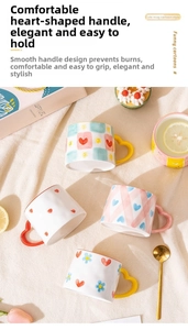 Detail of cute ceramic mugs featuring colorful heart-shaped handles and hand-painted patterns