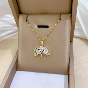 Detail of gold ginkgo leaf necklace with sparkling pear-shaped zircons in a jewelry box