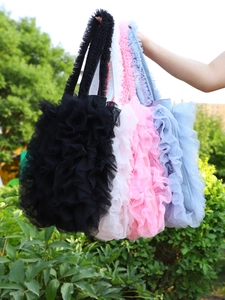 Close-up of mesh tote bags with ruffled lace edges in black, white, pink and blue