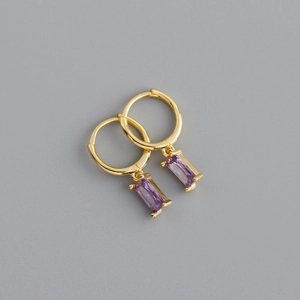 Dettaglio di orecchini a cerchio dorati con pendenti in pietra viola rettangolare