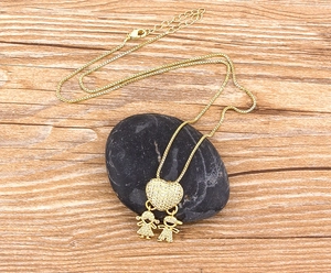Dettaglio della collana placcata oro 18k con ciondolo a cuore in zircone e figure bimbi