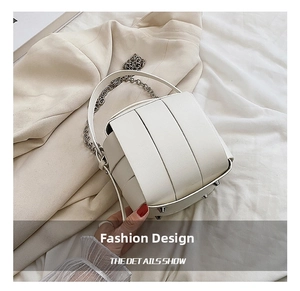 Detail view of white plaid box handbag with wide layered structure and silver chain strap