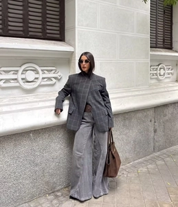 Détail d'un blazer à carreaux gris et d'un jean large à taille haute au style urbain moderne