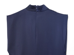 Dettaglio dell'abito in raso blu navy con cerniera invisibile e collo alto a lupetto