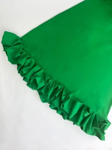 Close-up of bright green floral dress showing smooth fabric and ruffled hem details