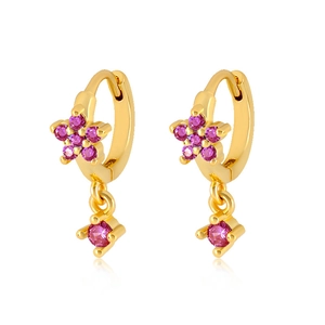 Detailed close-up of golden flower drop earrings with pink zircons on a white background