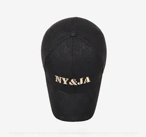 Top view of black baseball cap with golden NY&JA embroidery and subtle monogram pattern