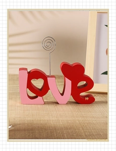Close-up of wood LOVE letters sign with heart shape and metal spiral memo clip holder