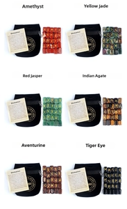 Detailed set of 25 polished rune stones in diverse natural crystals with velvet pouch