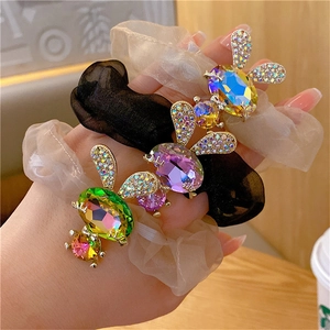 Detailed macro view of crystal-encrusted rabbit charms on premium elastic hair ties