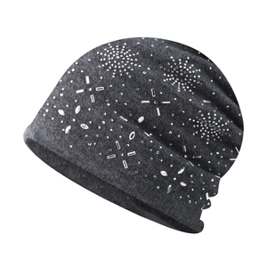 Detail of dark grey knit beanie with intricate silver rhinestone snowflake and star patterns