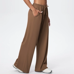 Detail of brown wide-leg yoga pants featuring elastic drawstring waist and side pockets