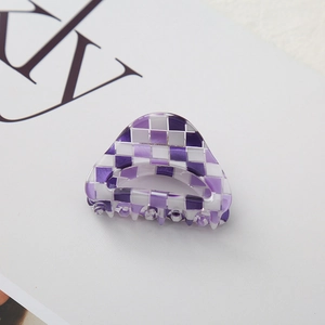 Macro detail of purple checkered acrylic hair claw clip with smooth polished edges