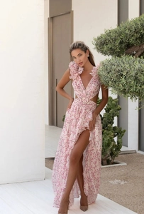 Detail of pink floral dress featuring deep V-neck, waist cut-outs and ruffled shoulders