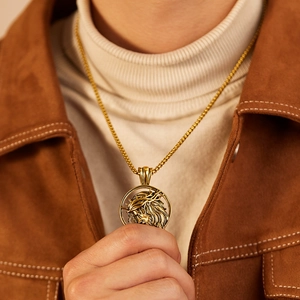 Close-up of golden stainless steel Jesus medallion pendant with thorns on a male model