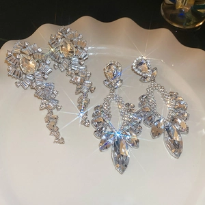 Vue détaillée de boucles d'oreilles en cristal argenté et franges sur plateau blanc