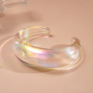 Macro shot of an iridescent thick-walled acrylic open cuff bracelet with rainbow luster