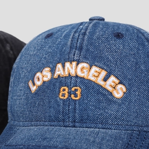Detailed close-up of Los Angeles 83 embroidery on blue denim baseball cap texture