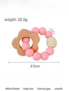 Detail view of pink silicone beads and beech wood flower on rabbit pacifier chain clip