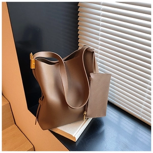 Detail of coffee brown leather hobo bag featuring gold lock and lychee texture