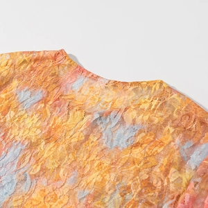 Detailed macro shot of the round neckline and sheer lace texture on women's crop top