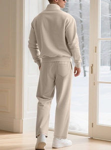 Detailed back view of men's beige knitted tracksuit featuring vertical ribbed texture