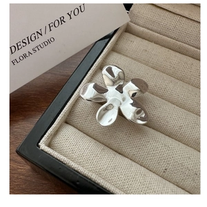 Vue macro d'une bague fleur à cinq pétales en argent 925 poli miroir dans un écrin cadeau