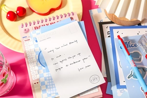 Detail of vintage stationery set with spiral planner, postcard and floral stickers