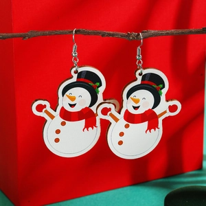 Detail of Christmas snowman earrings with red scarf hanging on a natural wooden branch