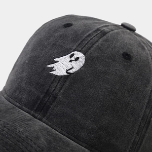 Macro view of ghost embroidery and washed cotton texture on a vintage baseball cap