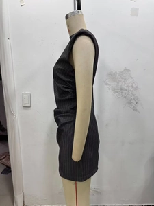 Detail view of the side ruching and pleated texture on a grey sleeveless slim dress