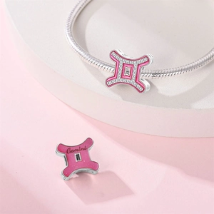 Pink Gemini zodiac charm in silver-plated copper with pink enamel and cubic zirconia