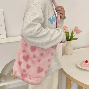 Detail view of pink leopard fuzzy shoulder bag with red heart pattern in lifestyle scene