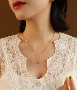 Close-up of 18K gold-plated star pendant necklace with zircon on elegant female model