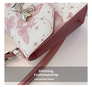 Detailed view of the fine stitching and silver butterfly buckle on the pink white bag