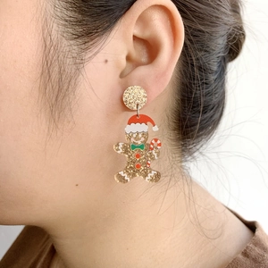 Gingerbread man acrylic earrings with gold glitter and red hat on model