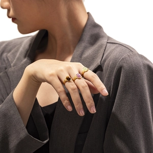 Macro shot of vintage style gold-plated rings with oval natural stones on a model