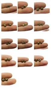 Detail of 13 antique bronze alloy spacer beads in various retro geometric shapes and patterns