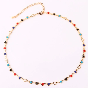 Flat lay of gold chain necklace with colorful enamel heart charms on white background