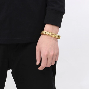 Gros plan détaillé du bracelet cubain tressé doré avec nœud central porté par un homme