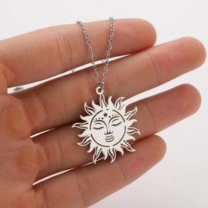 Detailed view of hand-held silver sun face pendant necklace with geometric hollow design