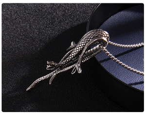 Vue macro du pendentif serpent argenté montrant les détails des écailles et du métal