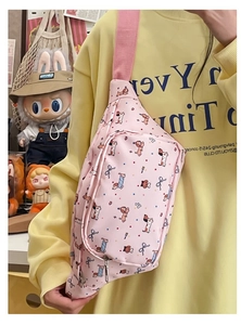 Detailed view of pink cartoon dog crossbody bag featuring cute patterns and blue bows