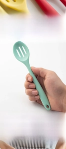 Detail of light green integrated silicone slotted spoon with ergonomic hanging handle