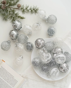 Close-up of silver and white assorted Christmas ornaments with glitter and matte finishes