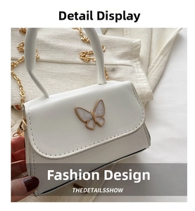 Vue détaillée du mini sac blanc avec papillon perlé et bandoulière chaîne dorée
