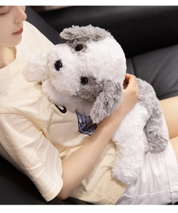 Close-up of soft grey and white plush puppy toy being hugged by a person