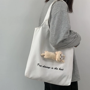 White canvas tote bag featuring cute plush cat charm and black lettered text on the side